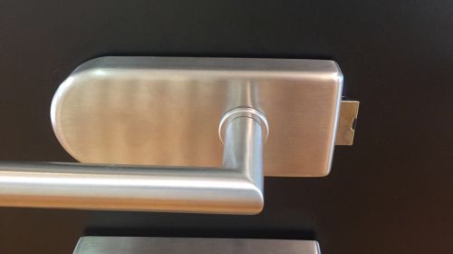 Silberner Türgriff auf schwarzer Oberfläche, modernes Design, glatte Textur.