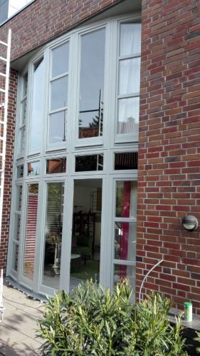 Backsteinfassade mit großen, weißen Fenstern; modernes Design, keine Personen.